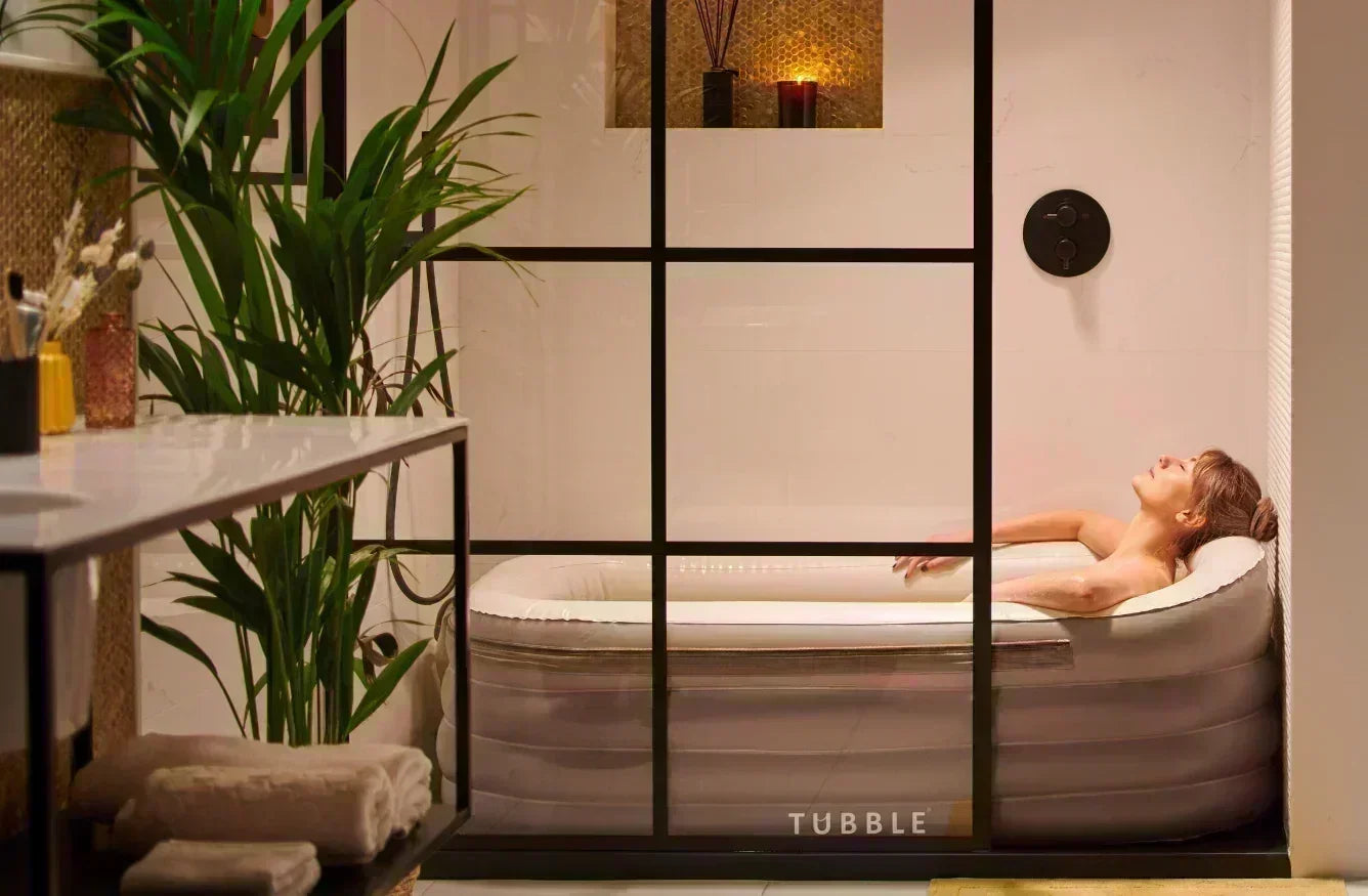 Person relaxing in a Tubble hot tub with a grid partition in a bathroom setting.