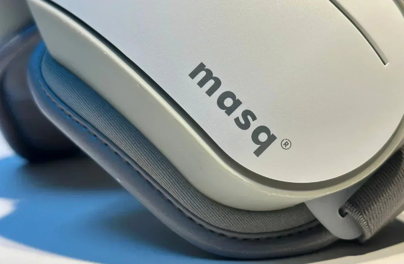 Close-up of a gray 'masq' branded product on a blue background