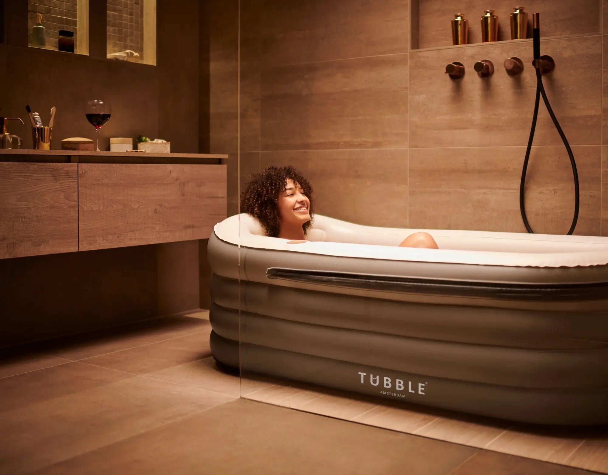 Person relaxing in an inflatable bathtub labeled 'Tubble' in a modern bathroom.